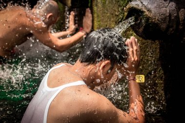 Bali, Endonezya - 5 Aralık 2017: Kutsal kaynak suyu. Tirta Empul tapınakta dua insanlar. Bali, Endonezya.