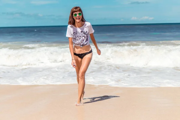 Belle jeune femme en lunettes de soleil posant sur la plage d'une île tropicale de Bali, Indonésie . — Photo