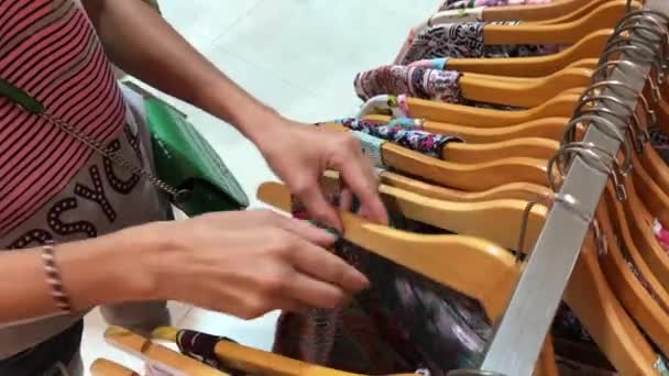 BALI, INDONÉSIA - DEZEMBRO 20, 2017: Mulher escolhendo roupas na loja de moda. Shopper mulher na boutique . — Vídeo de Stock