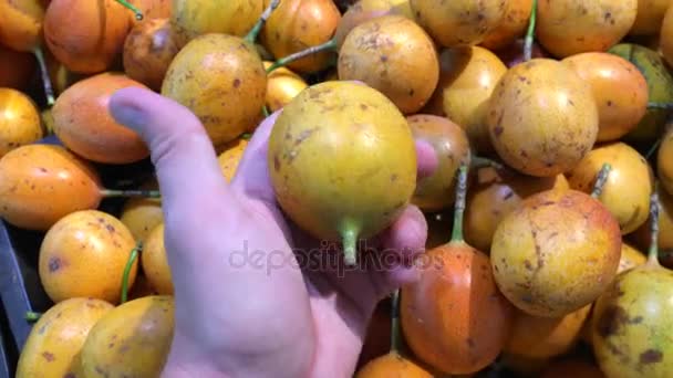 Hombre mano la selección de fruta de la pasión exótica orgánica fresca en el supermercado. Asia meridional, Indonesia, Bali . — Vídeo de stock