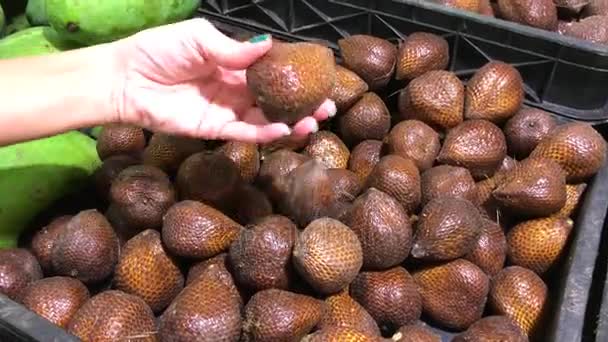 Schlangenfruchtsalak im Supermarkt. Frau wählt im Supermarkt frische exotische Bio-Früchte aus. — Stockvideo