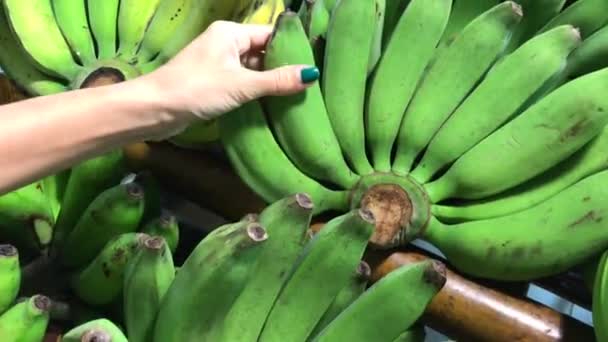 Mujer seleccionando plátano verde orgánico frsh en el supermercado en Asia . — Vídeo de stock