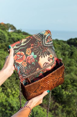 Kadın elleriyle lüks el yapımı yılan derisi deri çanta. Piton yılan moda çanta. Açık havada, Bali Adası.