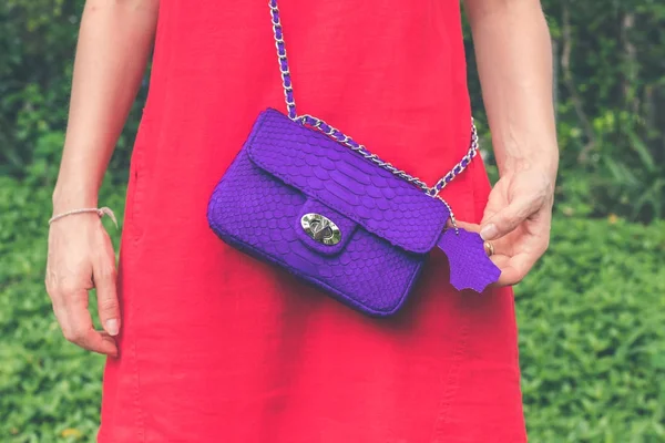 Woman hands with luxury handmade snakeskin leather handbag. Python snake fashionable handbag. Outdoors, Bali island.
