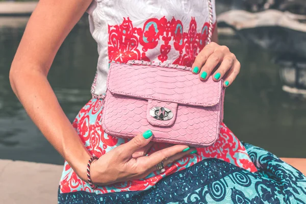 Woman hands with luxury handmade snakeskin leather handbag. Python snake fashionable handbag. Outdoors, Bali island.