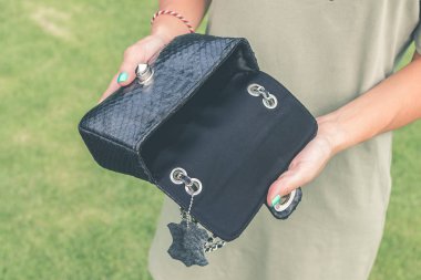 Kadın elleriyle lüks el yapımı yılan derisi deri çanta. Piton yılan moda çanta. Açık havada, Bali Adası.