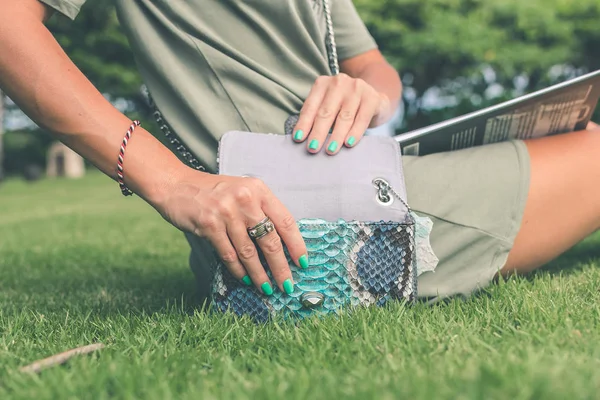 Frauenhände mit luxuriöser, handgemachter Handtasche aus Schlangenleder. Pythonschlange modische Handtasche. draußen, bali island. — Stockfoto