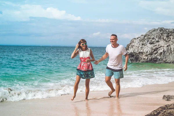 幸せな若い新婚旅行のカップルがビーチで楽しんで。海、バリ島、インドネシアで熱帯の休暇. — ストック写真