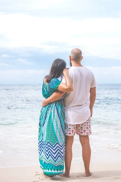 Happy young honeymoon couple posing on the beach. Ocean, tropical vacation on Bali island, Indonesia.