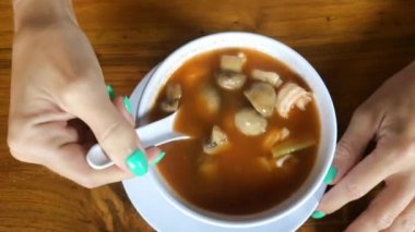Tom Yum Goong, karides, Balık ve mantar ile baharatlı Tay çorbası yemek kadın. Endonezya dili. Bali Adası. Asya.