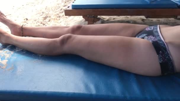 Jeune woamn relaxant sur une chaise de plage sur la plage tropicale de Bali île, Indonésie . — Video