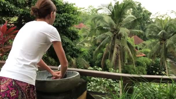 Mulher lavando as mãos lá fora com uma bela vista tropical. Conceito de frescura e ecologia. Ilha de Bali . — Vídeo de Stock