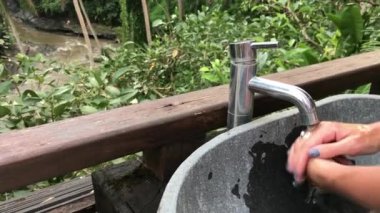 Kadın güzel bir tropik manzaralı dışında onun el yıkama. Tazelik ve ekoloji kavramı. Bali Adası.