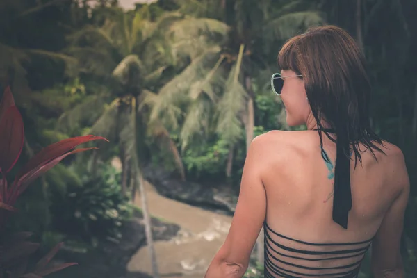 Jonge vrouw op een tropische rivier achtergrond. Bali eiland. — Stockfoto