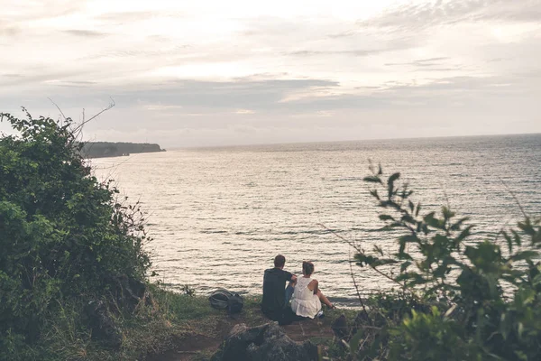A couple is standing on the edge of mountain on a tropical Bali island. — Stock Photo, Image