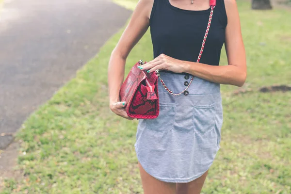 Frauenhand mit luxuriöser Schlangenhaut-Handtasche im Freien. tropische Mode exotisches Konzept. — Stockfoto