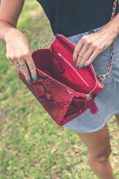Женская рука с роскошной сумкой из змеиной кожи на открытом воздухе. Экзотическая концепция тропической моды . — стоковое фото