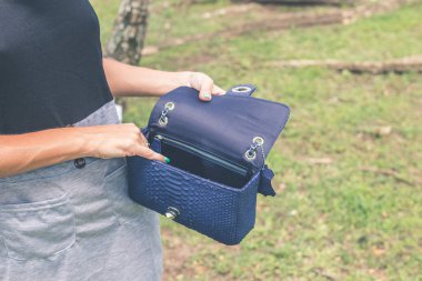 Kadın elleriyle lüks yılan derisi çanta açık havada. Tropikal moda egzotik kavramı.