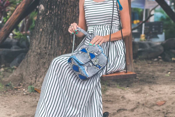 Frauenhände mit Luxus-Schlangenhaut-Handtasche im Freien. tropische Mode exotisches Konzept. — Stockfoto