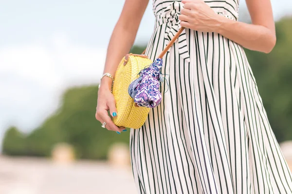 Frau mit modischer stylischer gelber Rattantasche und Seidentuch draußen. tropische Insel Bali, Indonesien. Handtasche aus Rattan und Seidenschal. — Stockfoto