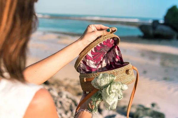 Vrouw met trendy stijlvolle rotan tas en zijden sjaal buiten. Tropische eiland Bali, Indonesië. Rotan handtas en zijden sjaal. — Stockfoto