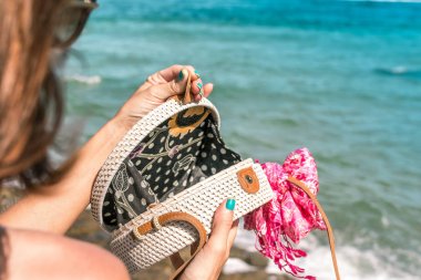 Şık şık beyaz rattan çanta ve İpek eşarp dışında kadın elle. Bali, Endonezya'nın tropik ada. Rattan el çantası ve İpek eşarp.