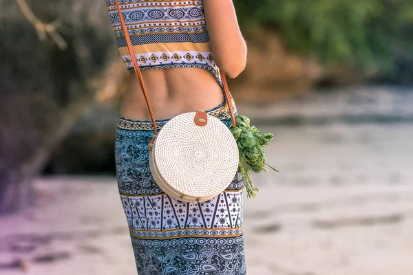 Женские руки с модной стильной сумкой из ротанга снаружи. Тропический остров Бали, Индонезия. Ротанг и шелк . — стоковое фото