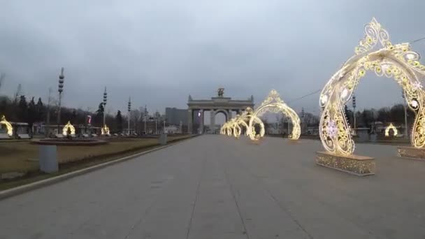 Moskva, Ryssland - 27 november 2019: Hyperlapse av huvudentrén till parken Vdnkh, julpynt. Utan färgkorrigering. — Stockvideo