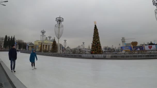 MOSCA, RUSSIA - 27 NOVEMBRE 2019: Le persone che cavalcano sulla pista di pattinaggio su ghiaccio della grande città al VDNKh . — Video Stock