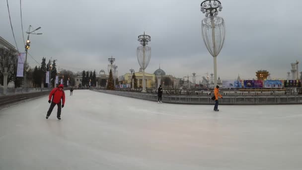 Moskva, Ryssland - 27 november 2019: Folk rider på storstadens skridskobana i Vdnkh. — Stockvideo