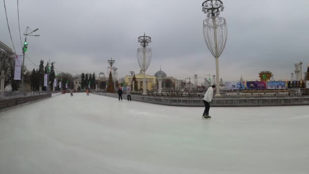 モスクワ,ロシア- 2019年11月27日:人々はVdnkhで大きな都市のアイススケートリンクに乗って. — ストック動画