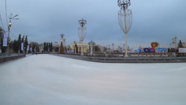 MOSCOW, RÚSSIA - NOVEMBRO 27, 2019: Pessoas andando na pista de patinação no gelo da cidade grande em VDNKh. Hiperlapso . — Vídeo de Stock