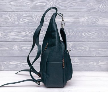 Tahta arka planda sentetik deri bir sırt çantası. Eko deri çanta..