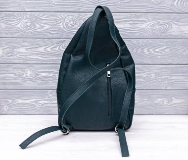 Tahta arka planda sentetik deri bir sırt çantası. Eko deri çanta..