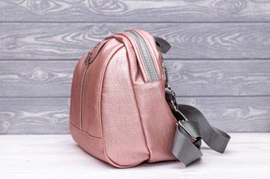 Tahta arka planda sentetik deri bir sırt çantası. Eko deri çanta..