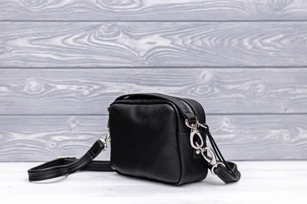 Модна синтетична шкіряна чорна сумка на дерев'яному тлі. Екошкіра . — стокове фото