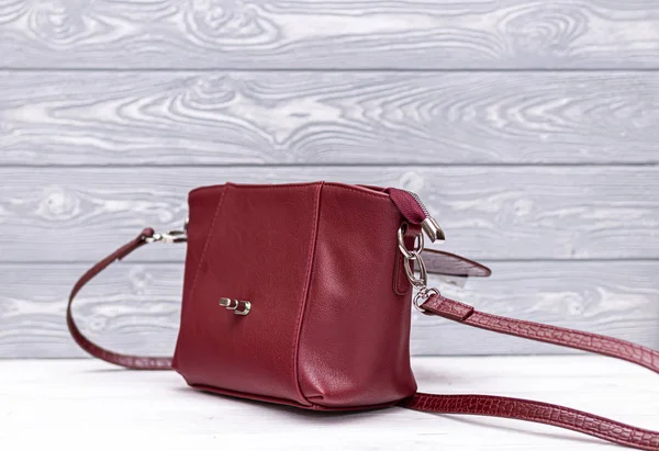 Módní syntetická kožená červená kabelka na dřevěném pozadí. Eko kůže. — Stock fotografie