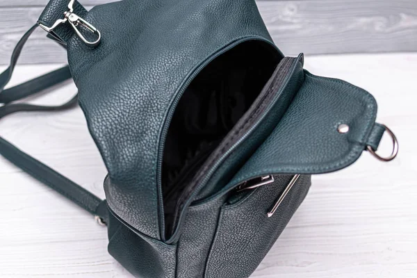 Konstläder grön ryggsäck på en trä bakgrund. Ekologisk läderväska. — Stockfoto