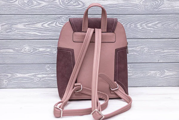 Kunstleder rosa Rucksack auf einem hölzernen Hintergrund. Tasche aus Kunstleder. — Stockfoto