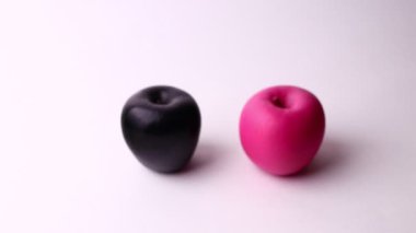 Two apples isolated on a white background. Pink and black apple, strange and funny shot.