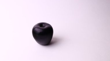 Two apples isolated on a white background. Pink and black apple, strange and funny shot.