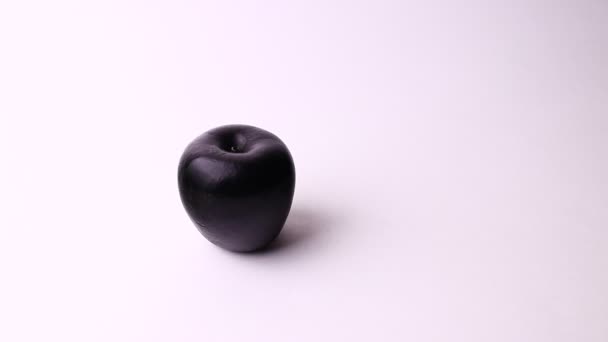 Two apples isolated on a white background. Pink and black apple, strange and funny shot. — Stock video