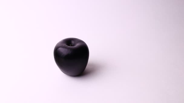 Dos manzanas aisladas sobre un fondo blanco. Rosa y negro manzana, extraño y divertido tiro . — Vídeos de Stock