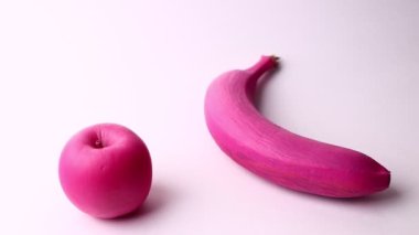 Pink banana and pink apple isolated on a white background. Studio shot, full HD.