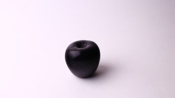 Funny black apple isolated on a white background. Full HD shot. — Stockvideo