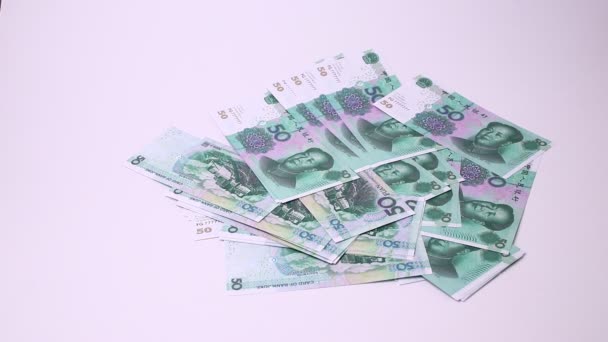 Юань китайской валюты и кости изолированы на белом фоне. Студийные кадры, несмонтированные . — стоковое видео