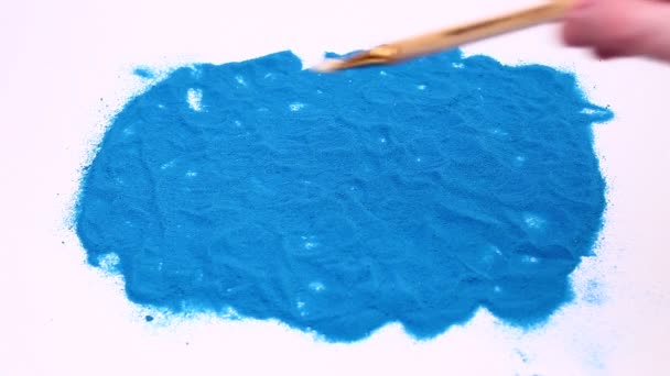 Чоловік пише номер два на синьому художньому піску. Студійні кадри на білому тлі . — стокове відео