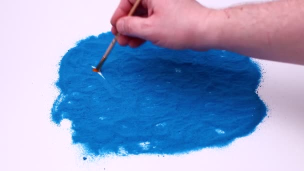Man hand skriva ett ord Yoga på en blå konst sand. Studio-bilder på en vit bakgrund. — Stockvideo