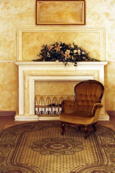 Velvet armchair on a background of a fireplace — Stock Photo, Image