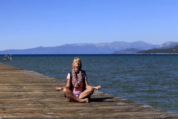 Meditace jóga dívka na pláži na Lake Tahoe — Stock fotografie